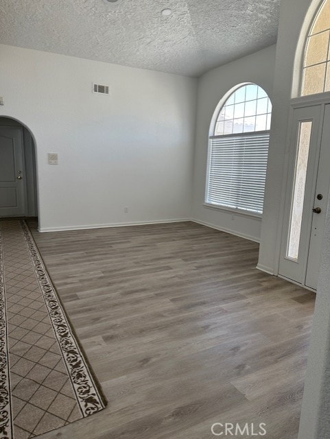 foyer entrance with wood-type flooring and a textured ceiling