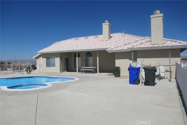 view of swimming pool featuring an in ground hot tub and a patio area