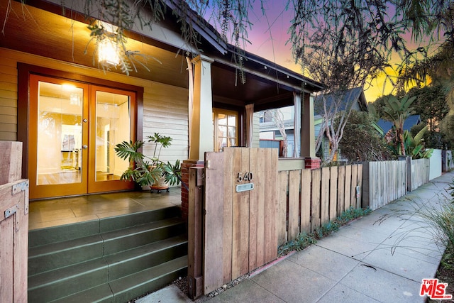 property exterior at dusk featuring french doors