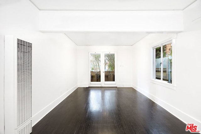 spare room featuring french doors, dark hardwood / wood-style flooring, and a wealth of natural light