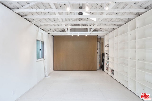 basement featuring tile patterned flooring, rail lighting, and wooden ceiling