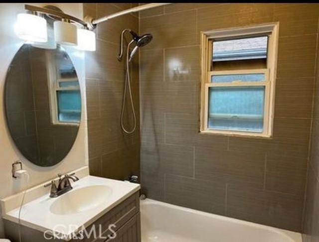 bathroom with vanity and tiled shower / bath combo