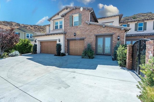 view of front of property with a garage, french doors, and a mountain view