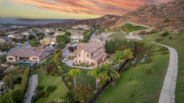 aerial view at dusk featuring a mountain view