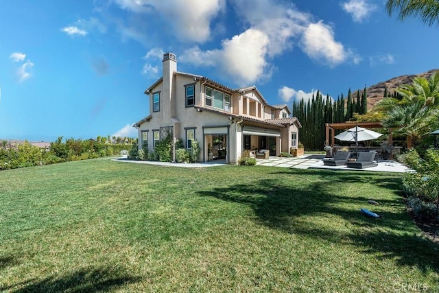 rear view of property with a yard, outdoor lounge area, and a patio area