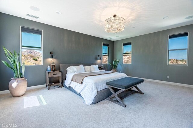 carpeted bedroom with an inviting chandelier and multiple windows