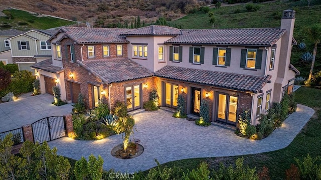 rear view of property with a garage and french doors