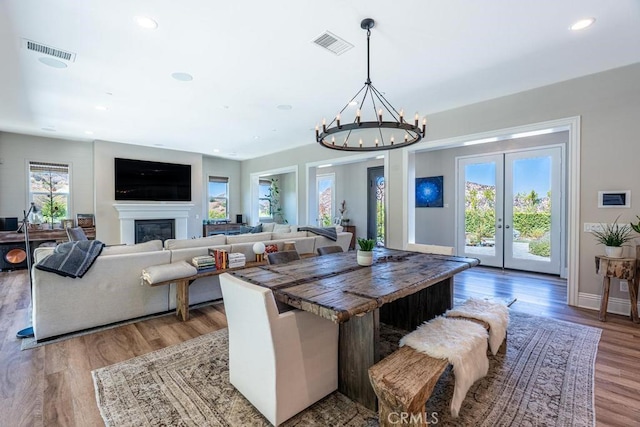 dining room featuring a notable chandelier, french doors, and wood-type flooring