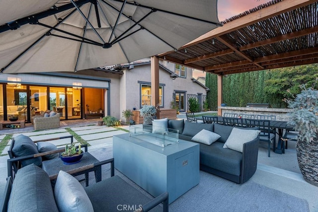 patio terrace at dusk featuring a bar and an outdoor living space