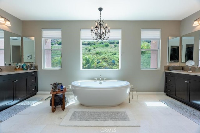 bathroom with vanity, a chandelier, plenty of natural light, and a bathing tub