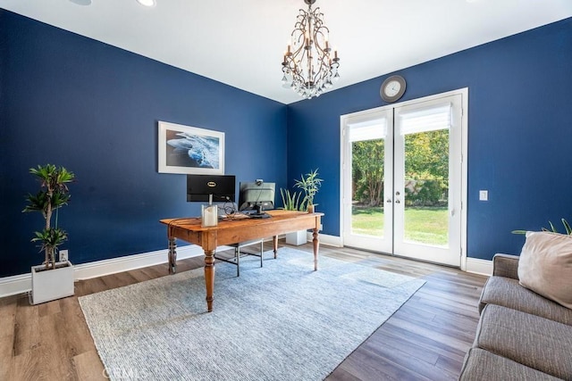 home office featuring french doors, hardwood / wood-style flooring, and a notable chandelier