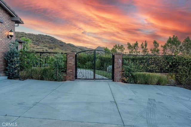 gate at dusk featuring a mountain view