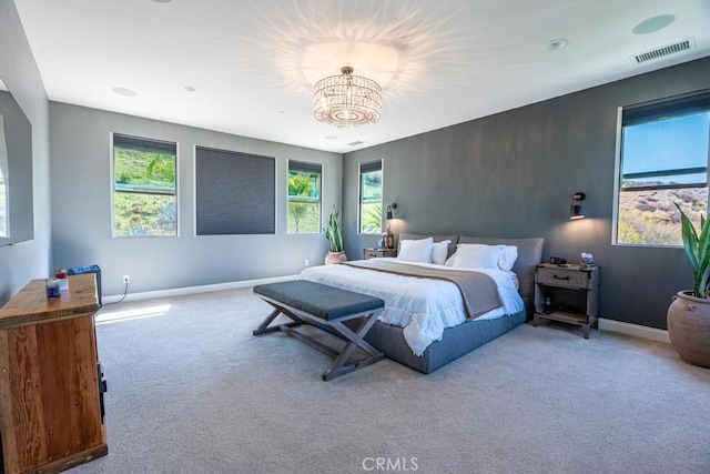 bedroom with a chandelier and light colored carpet