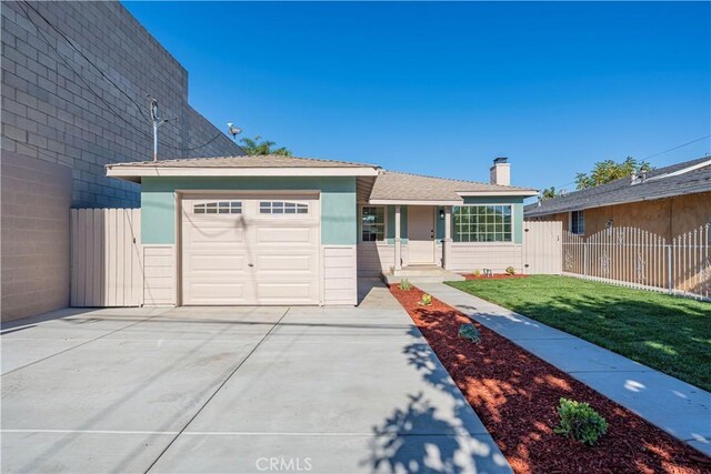 ranch-style house featuring a garage and a front lawn