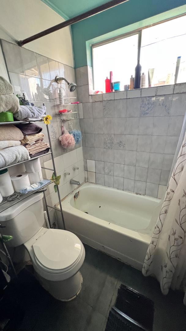 bathroom featuring shower / tub combo, tile patterned floors, and toilet