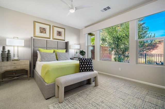 bedroom featuring carpet, ceiling fan, and multiple windows