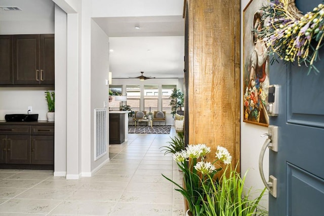 tiled foyer featuring ceiling fan