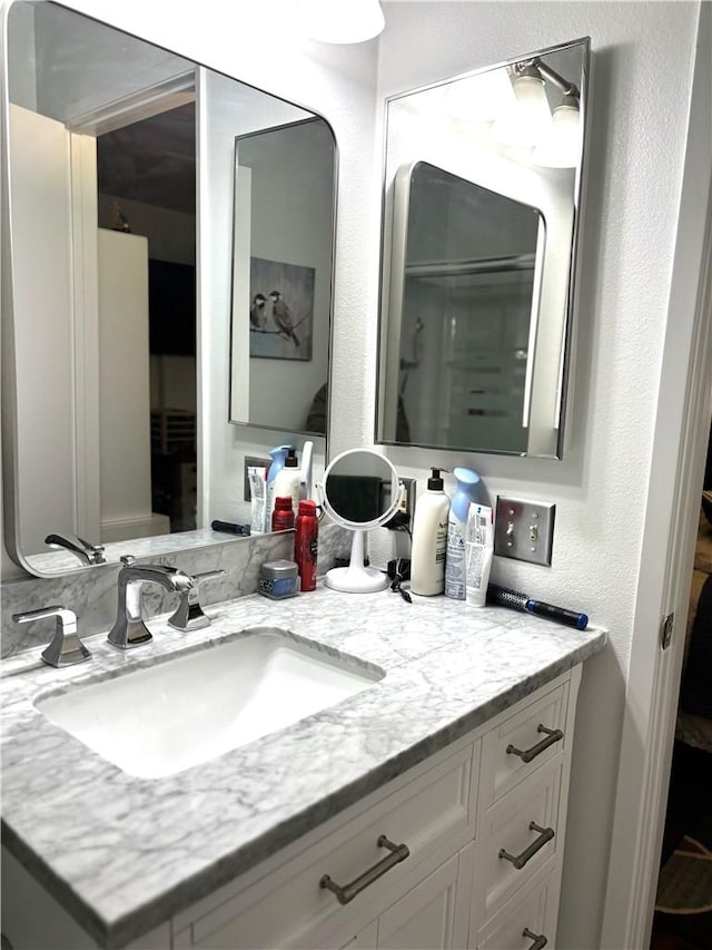 bathroom with a textured wall and vanity