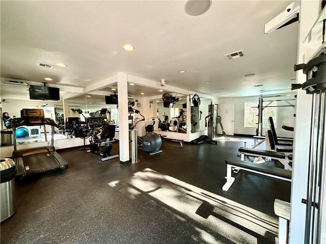 gym featuring recessed lighting, visible vents, and a textured ceiling