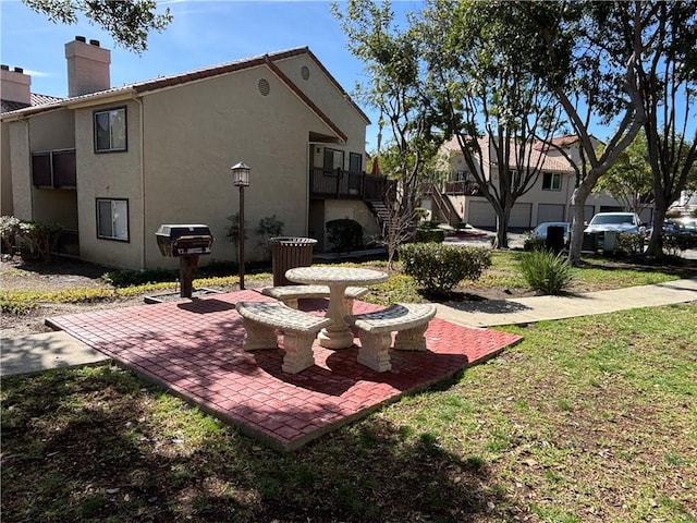 surrounding community featuring a garage, stairway, a patio area, and a lawn