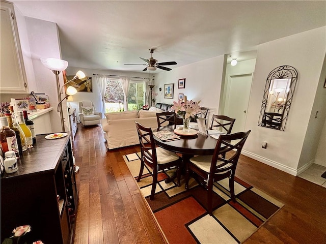 dining area with ceiling fan, dark wood-type flooring, and baseboards