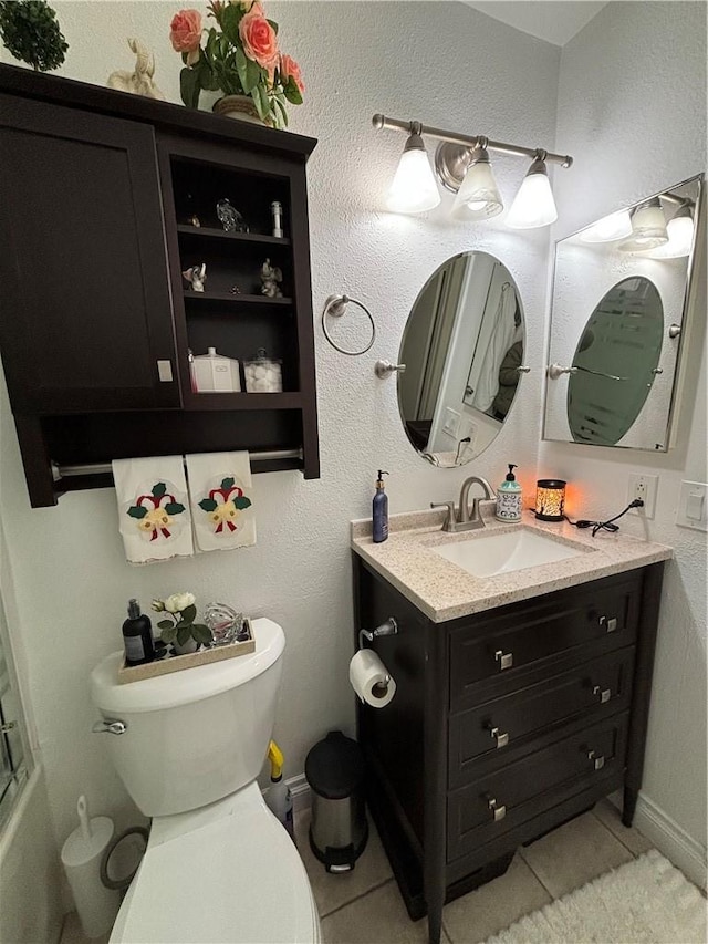 bathroom with tile patterned flooring, baseboards, vanity, and toilet