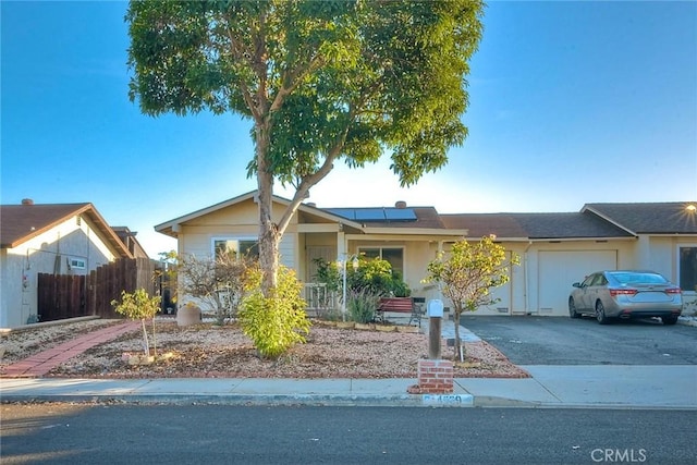 ranch-style home featuring solar panels and a garage