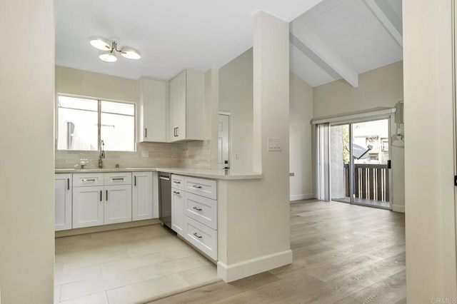 kitchen featuring tasteful backsplash, sink, lofted ceiling with beams, white cabinets, and light hardwood / wood-style floors