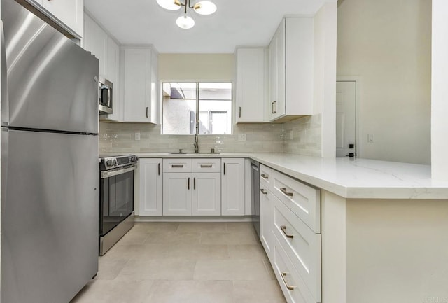 kitchen featuring white cabinets, stainless steel appliances, kitchen peninsula, and sink