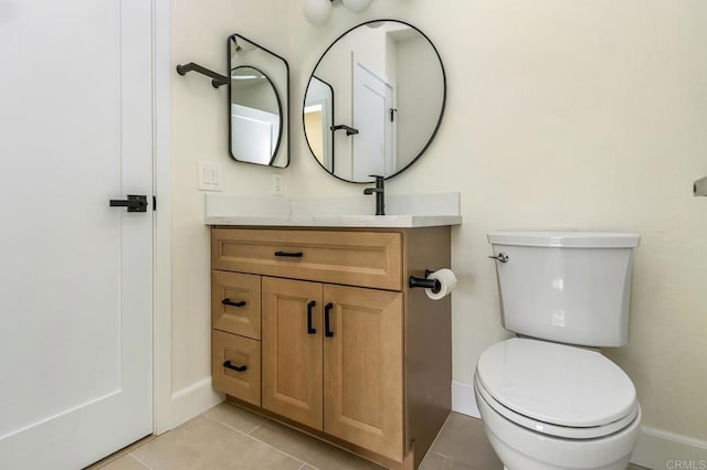 bathroom with toilet, vanity, and tile patterned floors