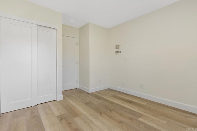 unfurnished bedroom with light hardwood / wood-style floors and a closet