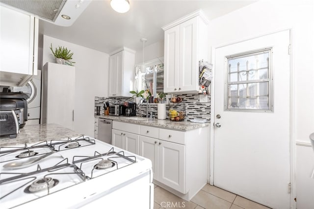 kitchen with dishwasher, sink, light tile patterned floors, tasteful backsplash, and white cabinetry