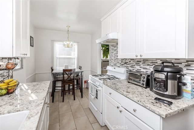 kitchen with tasteful backsplash, white gas range, white cabinets, and a chandelier