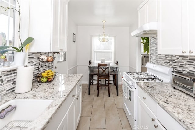 kitchen featuring decorative backsplash, plenty of natural light, white cabinets, and white stove