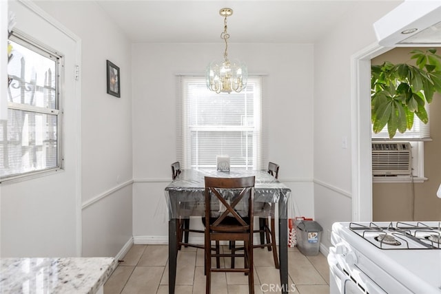 tiled dining room featuring a wealth of natural light, cooling unit, and a chandelier