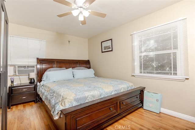 bedroom featuring ceiling fan, light hardwood / wood-style flooring, and cooling unit