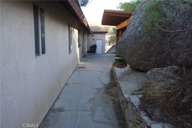 view of side of property with a patio and stucco siding