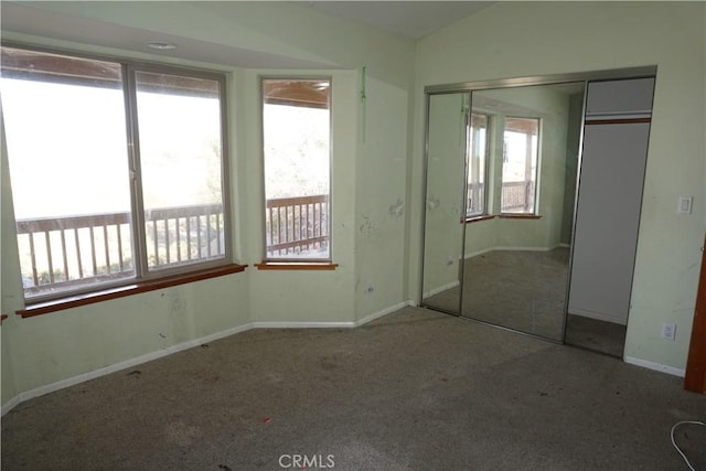 unfurnished bedroom featuring carpet flooring, a closet, and multiple windows