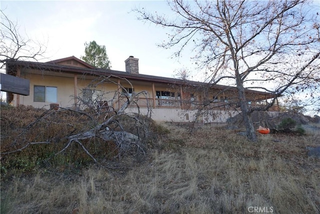 view of property exterior featuring a chimney and stucco siding