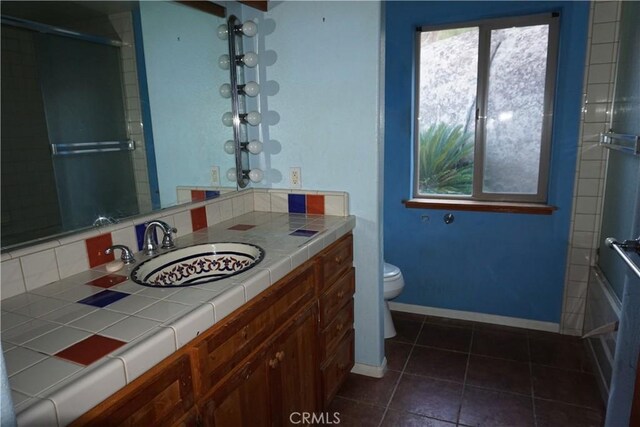 full bathroom with tile patterned flooring, vanity, toilet, and bath / shower combo with glass door