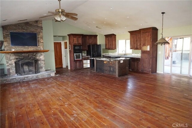 kitchen featuring a wealth of natural light, a kitchen island, dark hardwood / wood-style floors, and decorative light fixtures