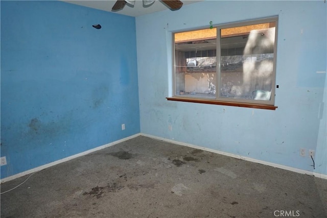 empty room featuring ceiling fan and baseboards