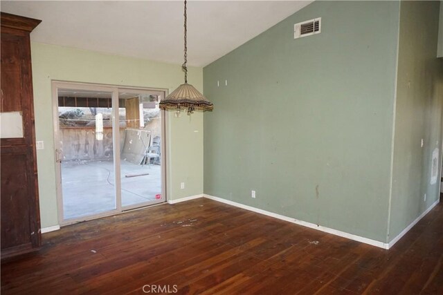 unfurnished dining area featuring dark hardwood / wood-style flooring and vaulted ceiling