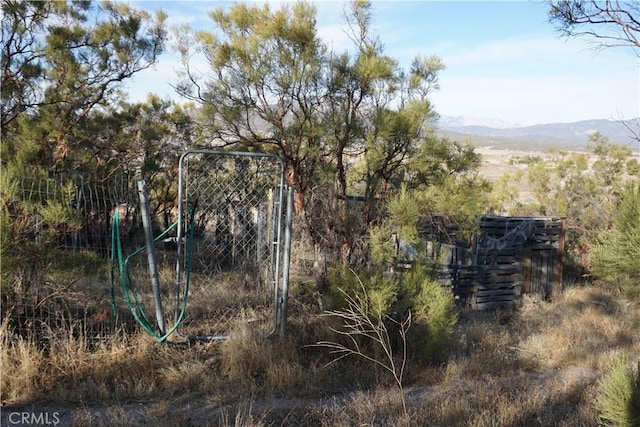 exterior space with a gate, a mountain view, and fence