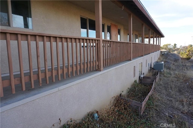 view of side of home featuring cooling unit and stucco siding