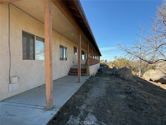 view of side of property with a patio and stucco siding