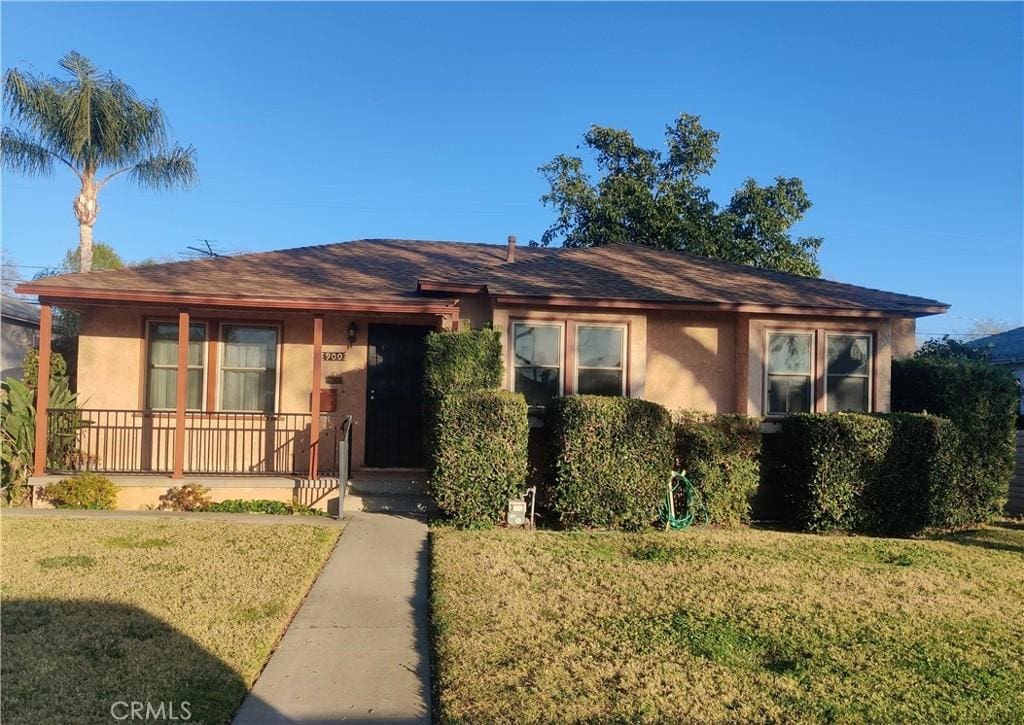 single story home with covered porch and a front lawn