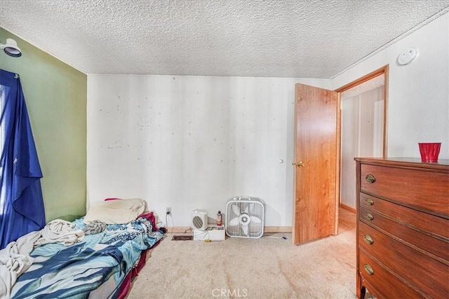 bedroom featuring light carpet and a textured ceiling