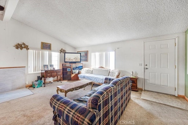 living area featuring a wealth of natural light, carpet, vaulted ceiling, and a textured ceiling