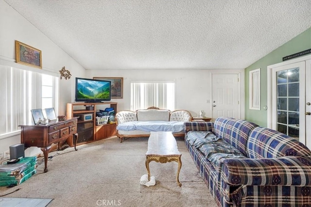 carpeted living area with lofted ceiling, french doors, and a textured ceiling